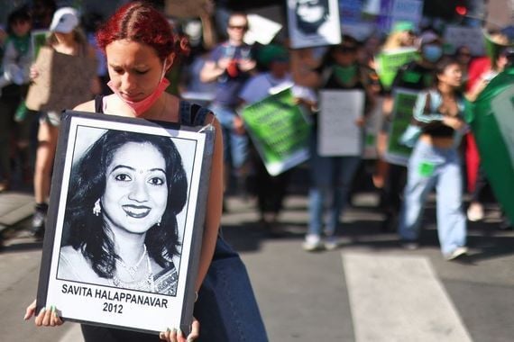 Irish protest for abortion rights. A protester holding a photo of Savita Halappanavar, who died 10 years ago in Ireland because she was denied an abortion.