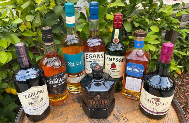 A selection of Irish whiskeys that are available in the US pictured atop a Bourbon cask. These casks are used in the aging process of Irish whiskey.