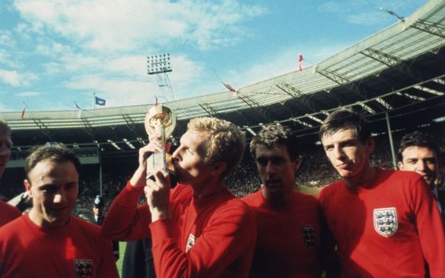 England captain Bobby Moore kissing the Jules Rimet trophy as the team celebrate winning the 1966 World Cup final against Germany at Wembley Stadium. 
