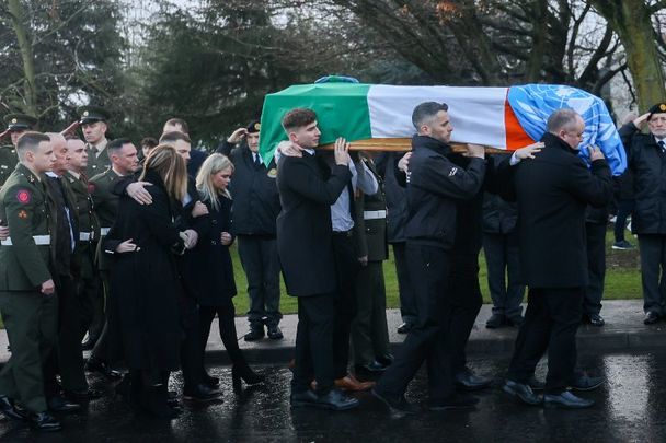 December 22, 2022: Mourners and members of the Defence Forces as the coffin of Pte Seán Rooney is carried to Holy Family Church, Dundalk.