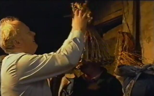 The Captain preparing a member of the group for the St. Stephen\'s Day, Hunting of the Wren.