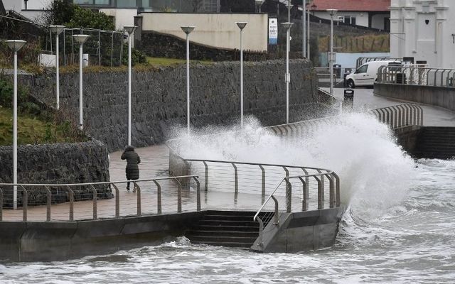 February 18, 2022: A woman runs from a crashing wave during Storm Eunice in Portstewart, Northern Ireland.