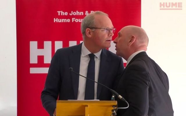 March 25, 2022: Ireland\'s Minister for Foreign Affairs Simon Coveney being told he has to evacuate during his speech for the John and Pat Hume Foundation\'s \"Building Common Ground\" event in North Belfast.