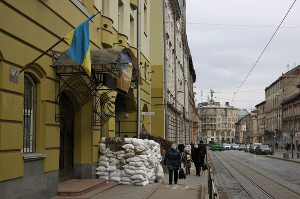 March 3, 2022: A woman walks past sandbags outside a building in Lviv, Ukraine. More than a million people have fled Ukraine following Russia\'s large-scale assault on the country, with hundreds of thousands of Ukrainians passing through Lviv on their way to Poland.