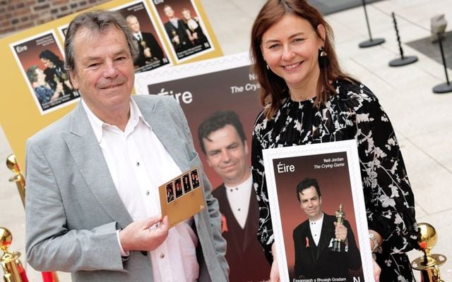 An Post\'s Debbie Byrne holds stamp artwork featuring Academy Award winner Neil Jordan (left).