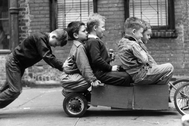 Boys playing in a go-kart on a New York sidewalk, circa 1955. 