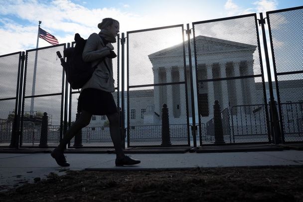 May 5, 2022: A person walks past non-scalable fencing after it was installed overnight around the US Supreme Court Building amid ongoing abortion-rights demonstrations in Washington, DC. Demonstrations across the country continue as abortion rights and anti-abortion advocates react to the leaked initial draft majority opinion indicating the US Supreme Court would overturn two abortion-related cases, which would end federal protection of abortion rights. 