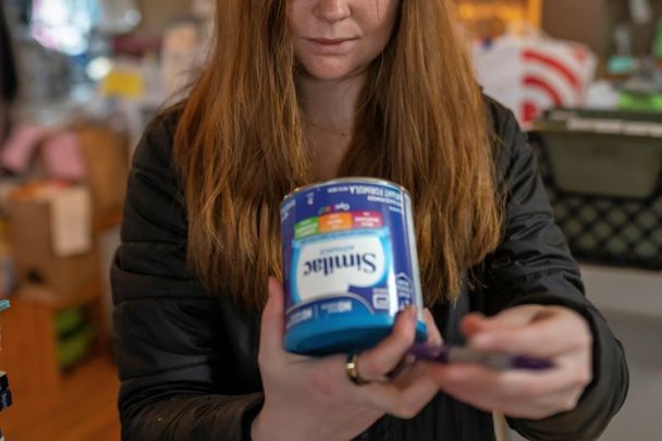 May 12, 2022: Katie Wussler, a program coordinator at Mother & Child Education Center, checks the lot number on a donated can of Similac baby formula against a list of recalled cans in Portland, Oregon.