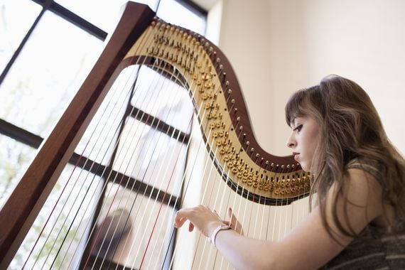 A harpist playing the harp at Dunluce Castle, County Antrim.