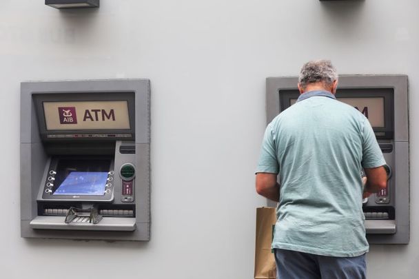 A person using the hole-in-the-wall AIB Automatic Teller Machine (ATM) to get money on Dublin\'s Grafton Street after AIB announced it would be going cashless in its rural posts, a decision that was soon reversed.