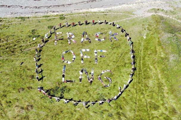 August 7, 2022: Climate activists take part in a mass trespass of the site of the proposed Shannon LNG gas import terminal. The group engaged in several actions, including spelling “Frack Off LNG!” with their bodies, followed by a ceilí.