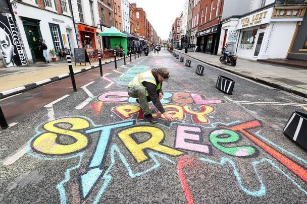 May 20, 2022: Tamas Lazar puts the finishing touches on new child-friendly artwork on Capel Street in Dublin on the first day it became traffic-free, becoming the longest pedestrianized street in Ireland. 