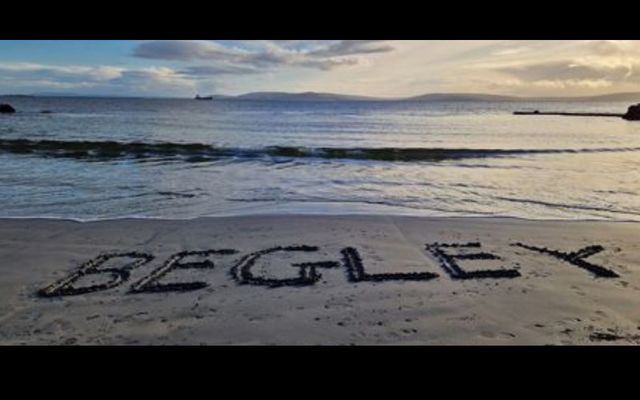 The word \"Begley\" carved into sand in Salthill, Galway as part of an international tribute to the late trad musician, Séamus Begley.