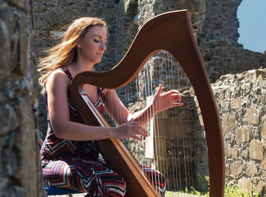 A musician playing the Irish harp at Dunluce Castle, in County Antrim.