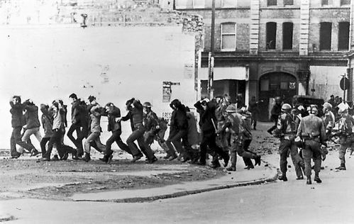 Members of the British Army\'s Parachute Regiment advance on marchers on Bloody Sunday.