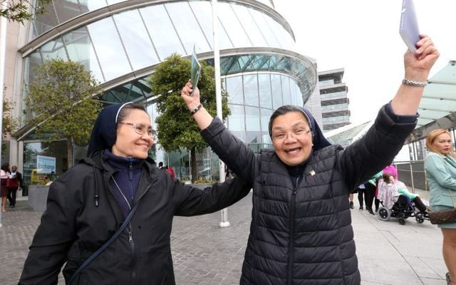 October 2, 2023: Sister Elvira Rossel (R) holding her Constitution of Ireland book and Sister Virginia Wamar from the Philipines at the Citizenship Ceremony in the Convention Centre in Dublin.