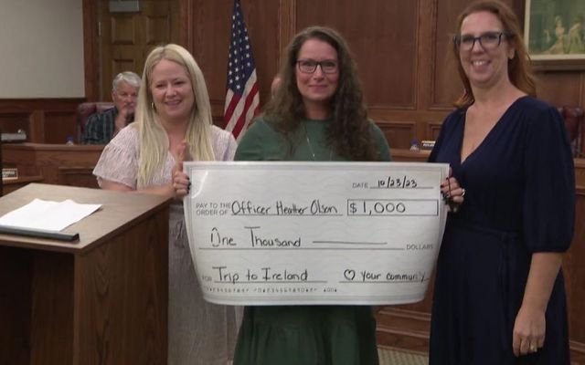 Heather Olson (center) is presented with a check for \$1,000. 