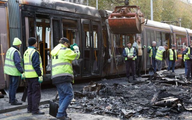 Crews work to remove a burned-out Luas in Dublin on Friday. 