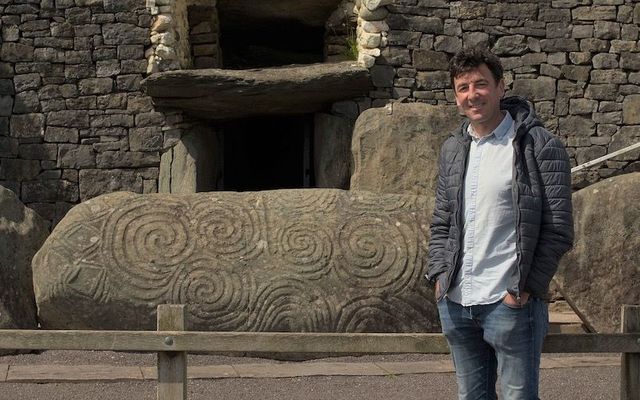 Seán Mac an tSíthigh, seen here at Newgrange, will seek to uncover the secrets of the ancient monument in \"Rún na Bóinne,\" a new documentary premiering on TG4 on December 20.