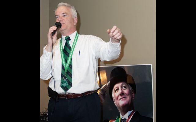 Michael E. McMahon at the Jerome X. O’Donovan Pre-Parade Breakfast in 2019. (Pictured behind McMahon is the late Jerome X. O’Donovan, former NYC Council Member.)\n 