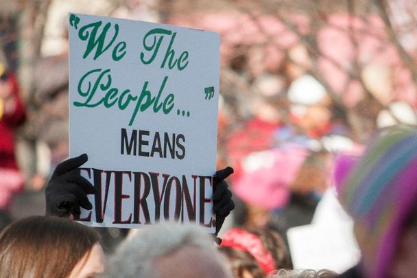 A protestor in Dayton, Ohio with a sign that says \"We The People Means Everyone.\"