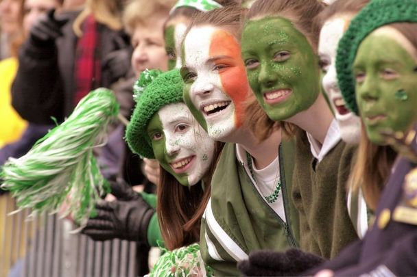 A group of women with their faces painted the colors of the Irish flag cheer during New York City\'s 240th St. Patrick\'s Day parade.