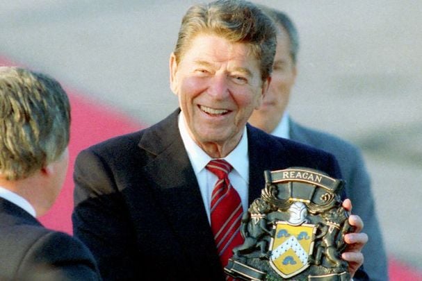 June 1, 1984: President Ronald Reagan holding his Coat of Arms during an arrival ceremony in Shannon, Ireland with Patrick Hillery and Garret Fitzgerald.