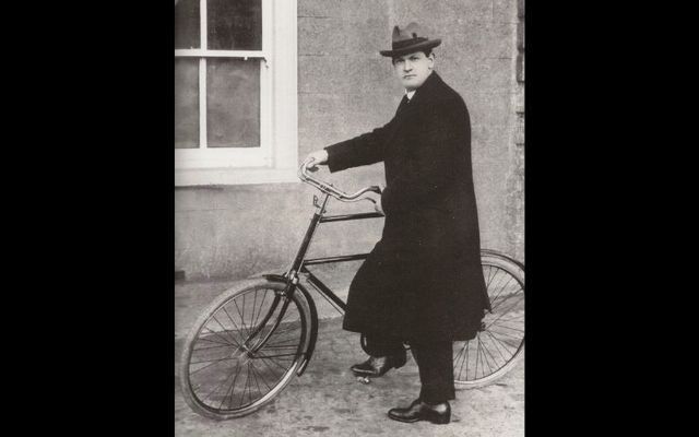 An iconic photograph of Michael Collins riding a Pierce bicycle. 