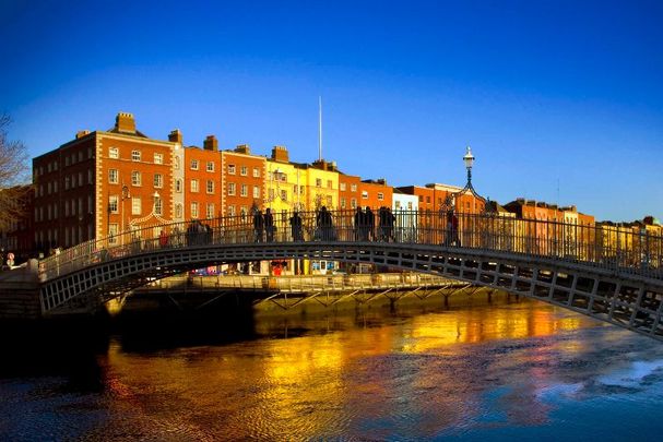 People walking across Dublin\'s Ha\'Penny Bridge.