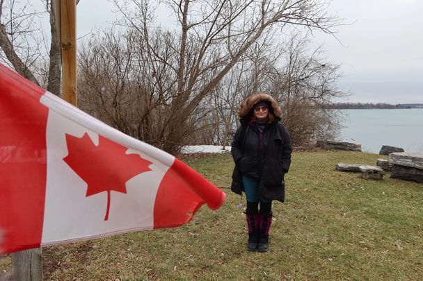 Jannet L. Walsh at Port Metcalf, the foot of Wolfe Island, Ontario, Canada. Canada to the left, and right is the United States.