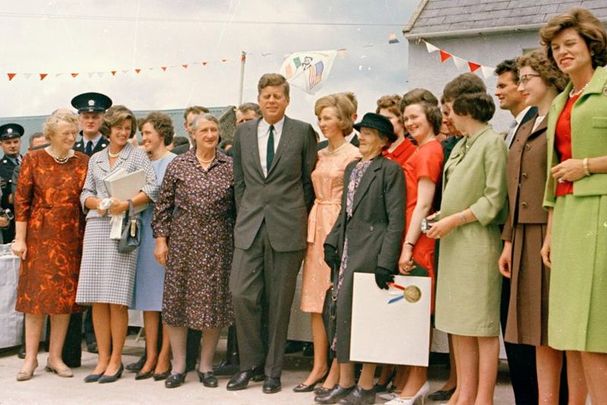 June 27, 1963: President John F. Kennedy with relatives during a reception at the Kennedy Homestead in Dunganstown, County Wexford, Ireland. L to R (in foreground): President Kennedy\'s second cousin once removed, Margaret Kirwan; sister, Jean Kennedy Smith; third cousin, Josephine \"Josie\" Ryan; second cousins once removed, Mary Ryan and James \"Jim\" Kennedy (mostly hidden behind the President); the President; his third cousin, Mary Ann Ryan; cousin, Margaret Whitty; third cousin, Joan Kirwan; several unidentified persons; the President\'s sister, Eunice Kennedy Shriver; and an unidentified man.