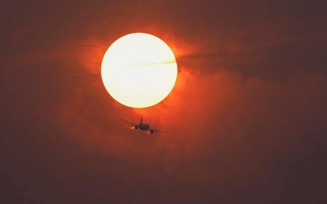 June 7, 2023: A commercial airline flies past the sun covered in haze made from smoke of Canadian wildfires in Washington, DC.