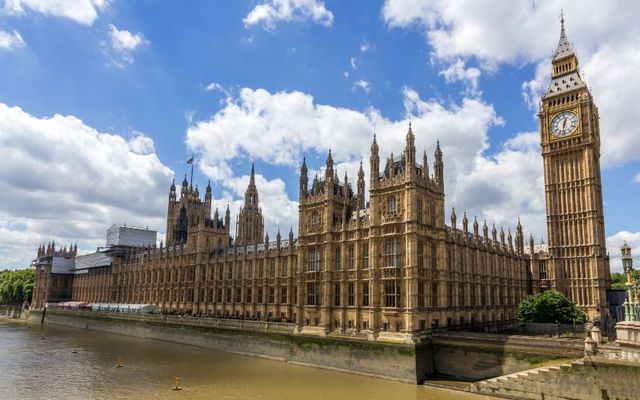 House of Commons and Palace of Westminster next to the Thames River in London, England.