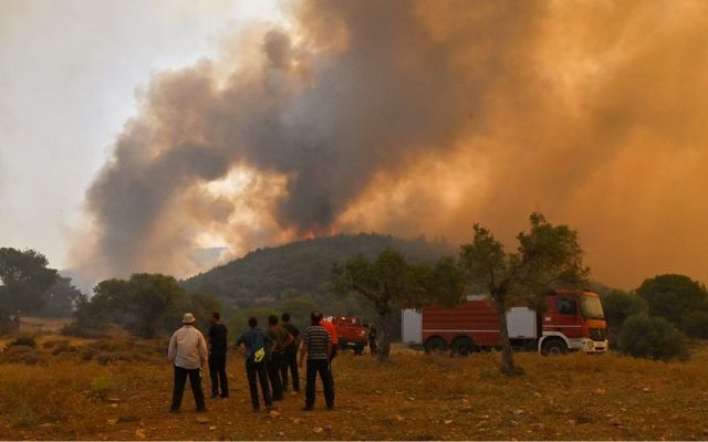July 19, 2023: : Locals watch a wildfire near the village Vlyhada near Athens in Athens, Greece.