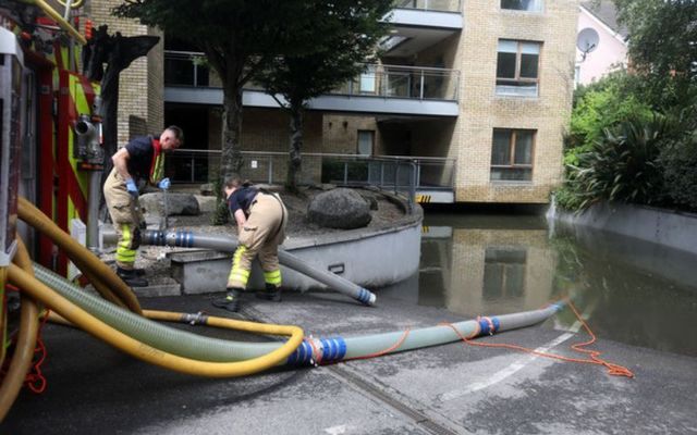 Members of Dublin Fire Brigade help out as they pump out water from the basement at the Auburn apartments in Clontarf.