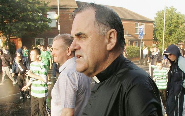 July 12, 2005: Fr Aidan Troy from the Holy Cross stands in the street after being hit by a police water cannon while trying to stop nationalist youths from attacking police officers from the PSNI during riots on the Crumlin Road in Belfast, Northern Ireland. 