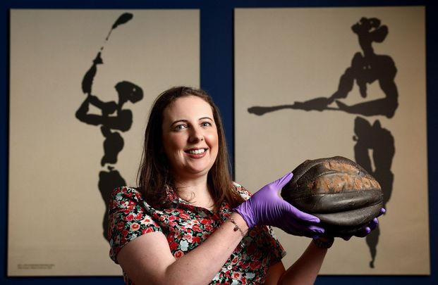 Dr Siobhán Doyle, Curator of \"GAA: People, Objects & Stories\", shows off a rugby football used by the prisoners to play Gaelic football in Frongoch internment camp in Wales in 1916.