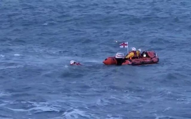 An RNLI member jumps into the water to save the young girl. 