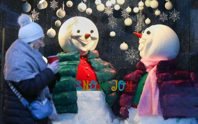 A woman bundled up against the cold weather as she passes the Arnott\'s Christmas window display on Henry Street in Dublin City Centre in 2022.