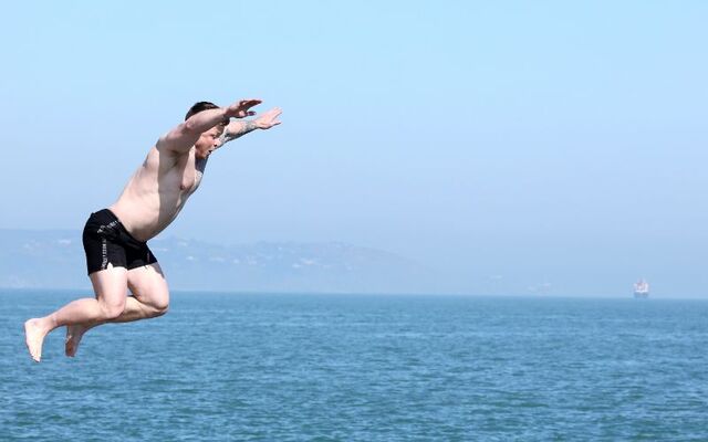 April 8, 2025: A swimmer jumping into the water while enjoying the good sunny weather at the Forty Foot in Dublin.
