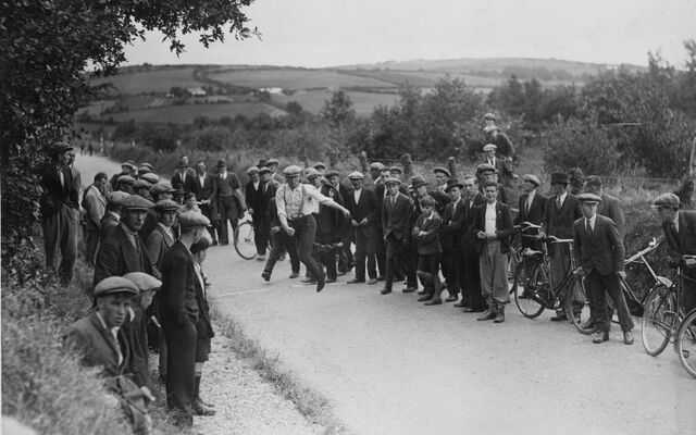 The noted Road Bowling player, Murphy Bawn (Murphy Brown) starts off his game with Conney Lucey with a mighty throw, on a deserted road near Blarney, County Cork.
