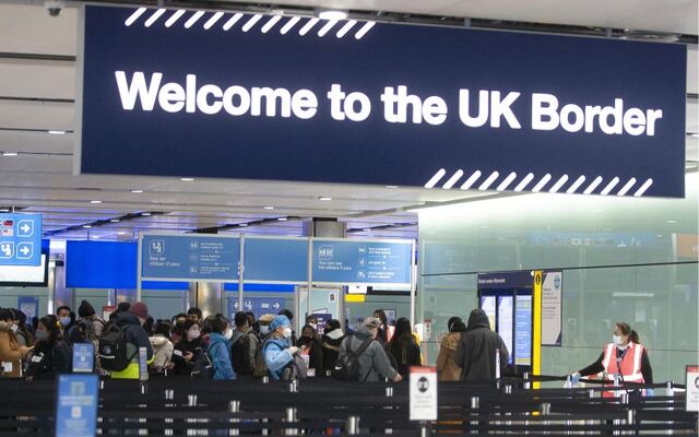 People queue at UK border control at Terminal 2 at Heathrow Airport in London.