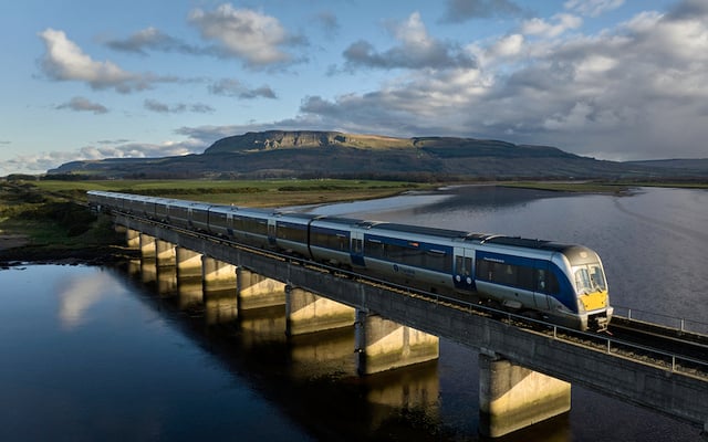 Train on railway crossing over River Roe near Binevenagh Mountain, Co Londonderry.