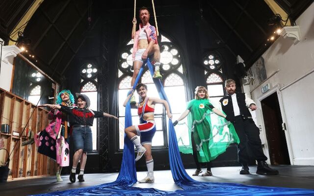July 8, 2025: Dublin Fringe Festival artists gather at Aerial Cirque Dublin to announce the 31st edition of the annual festival, running September 6-21. Pictured are Christopher McAuley (aerialist) and Emily Bradley (wrestling outfit), with Cabaret artists EGG (l to r) Goblins Goblins Goblins, Aoife Sweeney, DJ Anna Jacob, and Paul Prior.