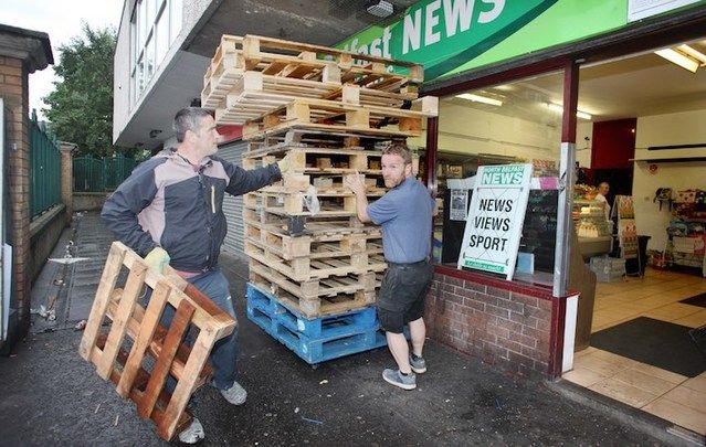 Sinn Féin's JJ Magee (right) and a member of the community removed wood from the New Lodge area