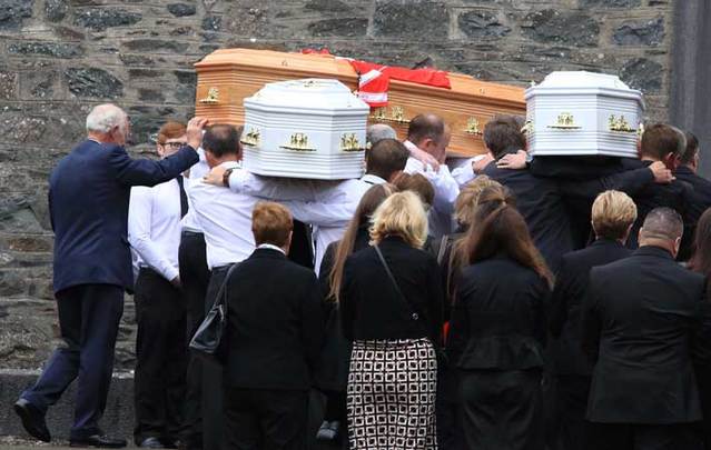 The bodies of the Hawe family arrive at the Church of St. Mary in Castlerahan in County Cavan. The photo shows the coffin of Alan Hawe, on the left, with his GAA club colors on top, and the coffins of two of his sons.