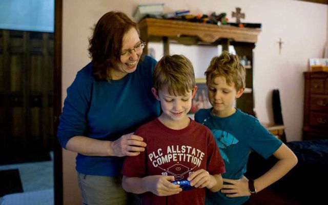 Celine Ryan who had advanced colon cancer at home with sons Decklan (7) center, and Liam (9) in Rochester Hills, Mich.