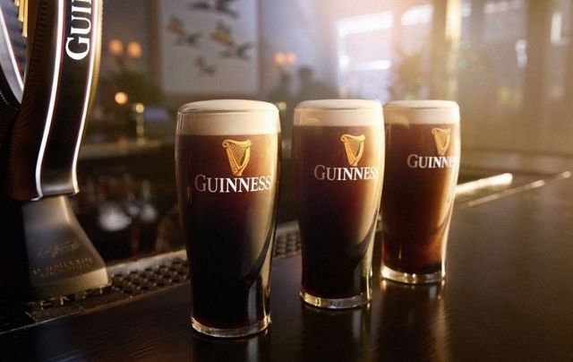 Pints of Guinness lined up after being poured.