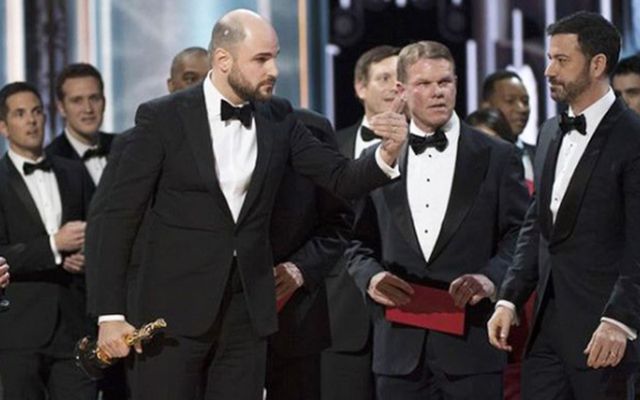 Brian Cullinan (center) on stage as realization hits that Moonlight won Best Movie.