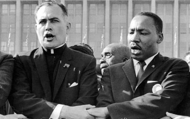 Father Ted Hesburgh singing with Martin Luther King Jr. during the Civil Rights fight.